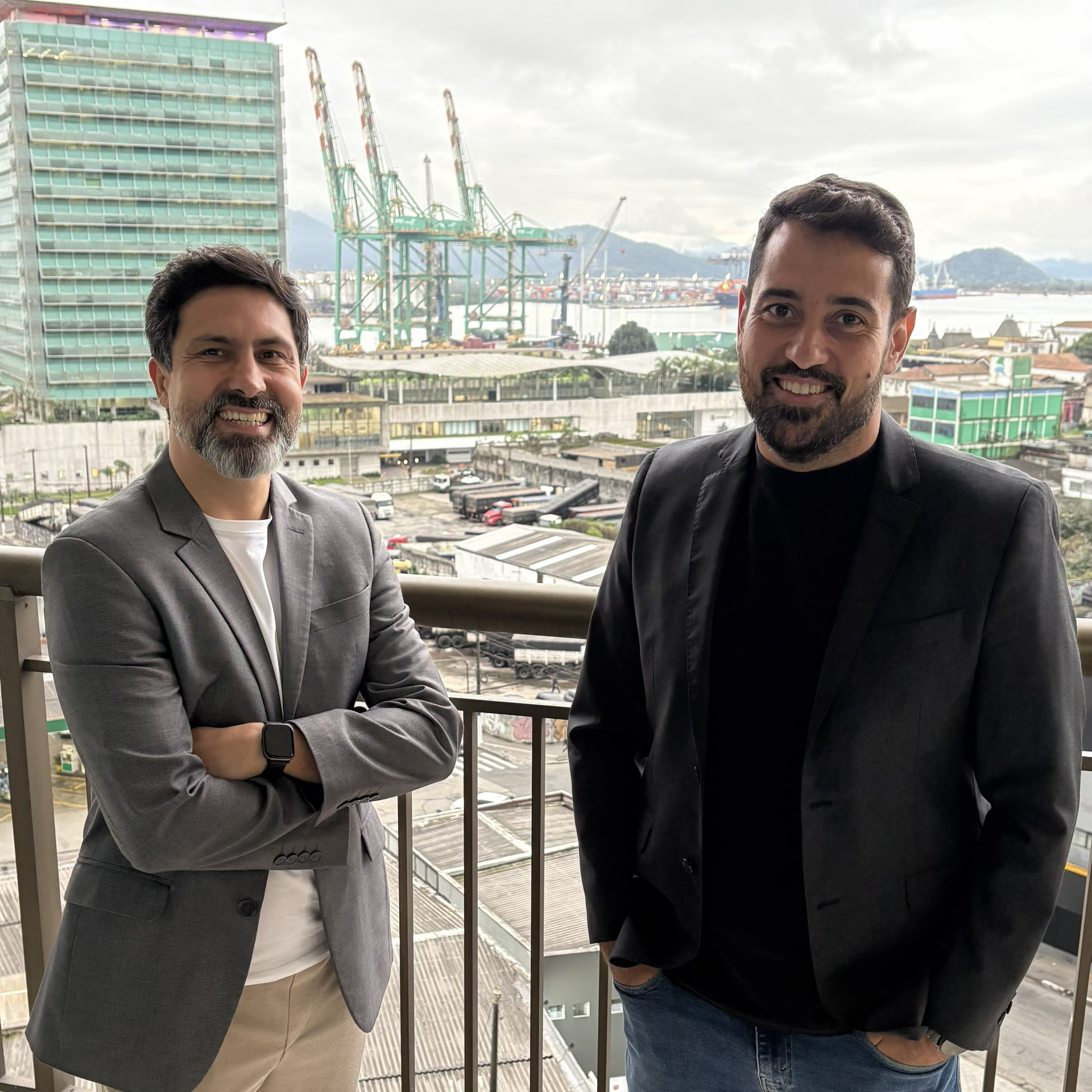 Alexandre Lemos e Eduardo Santos, sócios da DUAL, na varanda com o Porto de Santos ao fundo