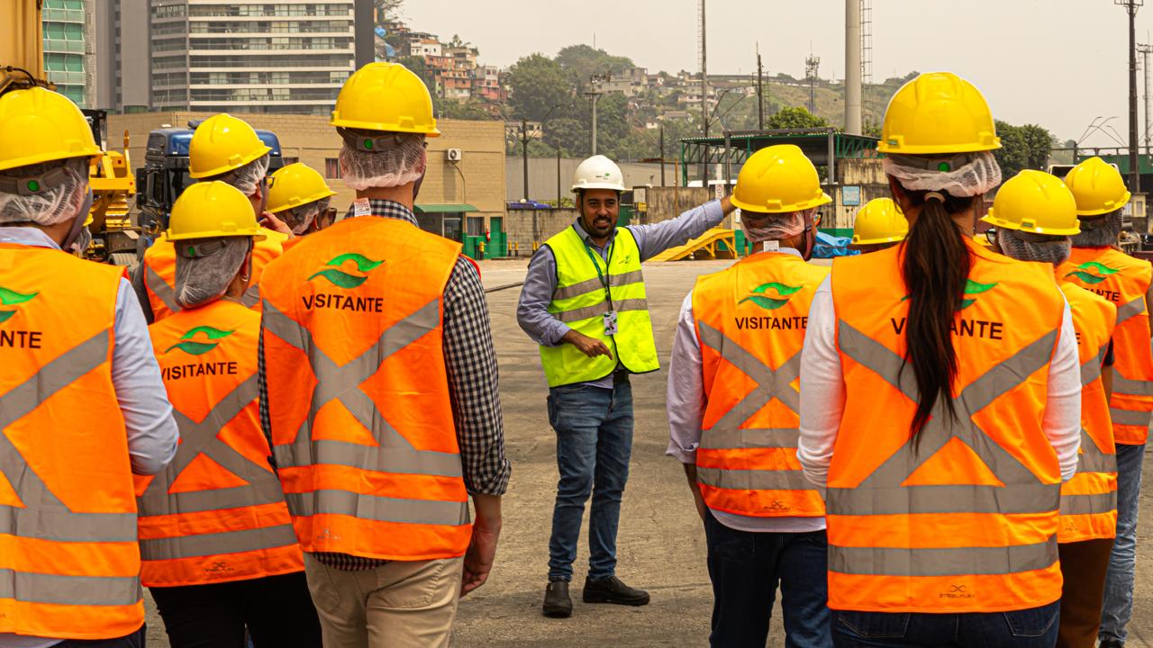 Instrutor conduzindo visita técnica em pátio de contêineres